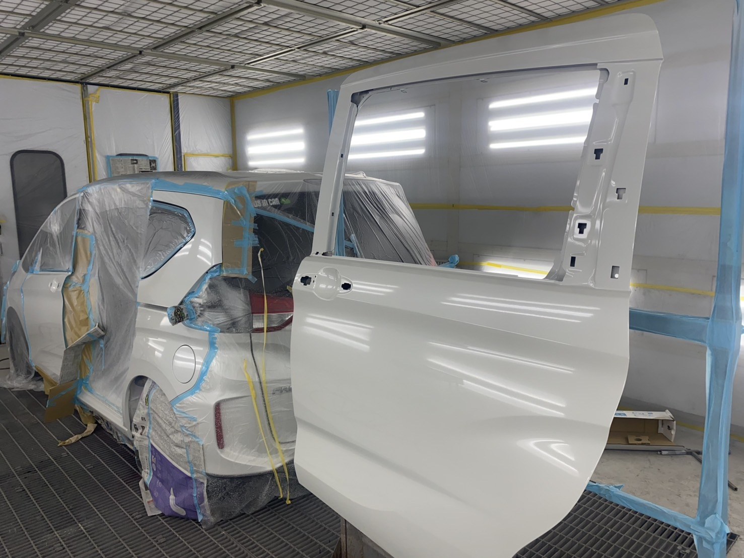 マスキングした車両のドア塗装作業